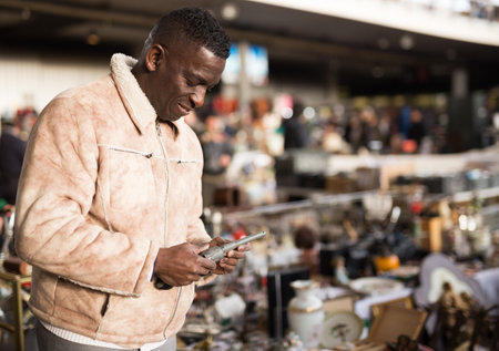 Man in a jacket chooses antiques at a flea marketの写真素材