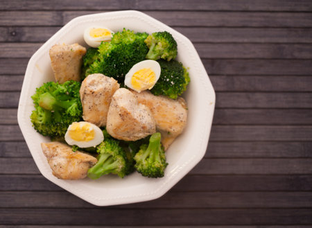 Healthy appetizer of chicken pieces with broccoli and quail eggs in bowl for healthy lunchの写真素材