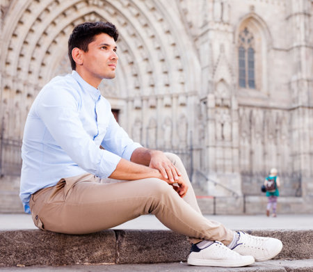Young European guy in blue shirt walking around cityの写真素材