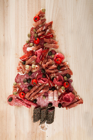 Christmas tree made of sausage on a background of a wooden wallの写真素材