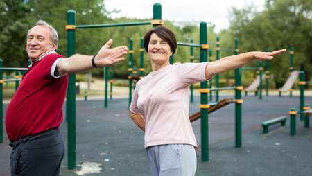 Sports pensioners do a warm-up on outdoor sports groundの写真素材