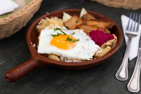 Scrambled eggs with fried bacon and potatoes served on plateの写真素材