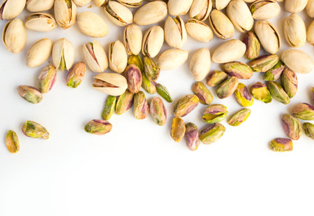 Roasted pistachio nuts on a white background and place for inscriptionの写真素材