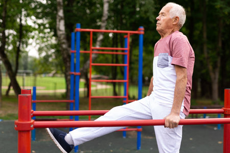 Elderly sportive man doing exercise in park