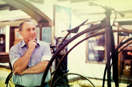 Mature man examines the exhibit in museumの写真素材