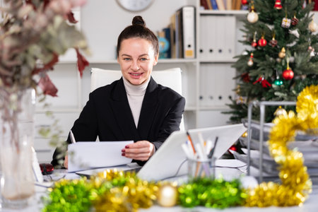 Woman working in workplace in Christmas decorated officeの写真素材