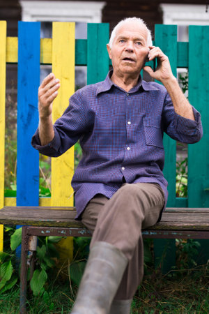 Senior man talking on phone outdoorsの写真素材