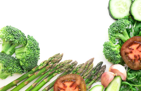 Frame of green vegetables broccoli, arugula, cucumber, asparagus, garlic on white background with place for inscriptionの写真素材