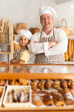 Dad and little daughter work sell in family bakery shopの写真素材