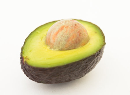 Halved avocado with bone on white background