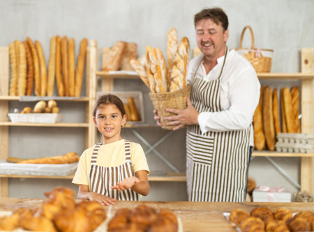 Father and little daughter - selling bread and various baguettesの写真素材