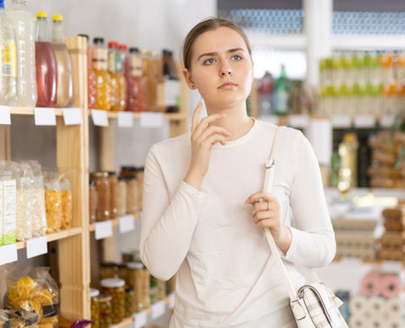 Young woman near the shelves in the supermarketの写真素材