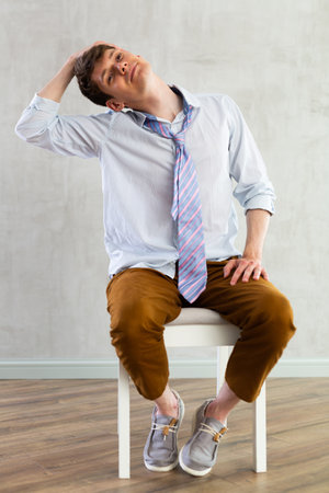 Young guy doing exercises on chairの写真素材