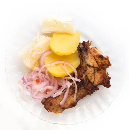 Dish of fried pork ribs, rice, potatoes, sweet potato and pickled onionsの写真素材