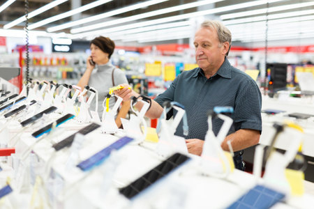 Elderly man chooses smart watch in storeの写真素材