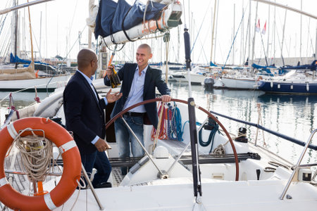 Men in suits relaxing on a yacht in the seaportの写真素材