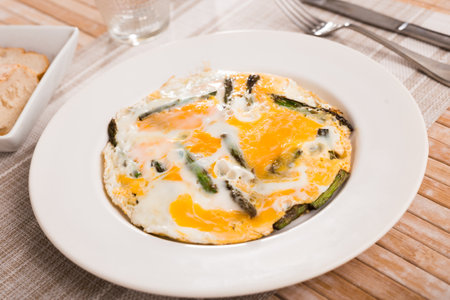 Closeup of fried eggs with asparagus at plateの写真素材