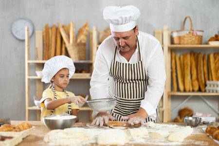 Bakers dad teaches daughter niece to work with dough, using rolling pin