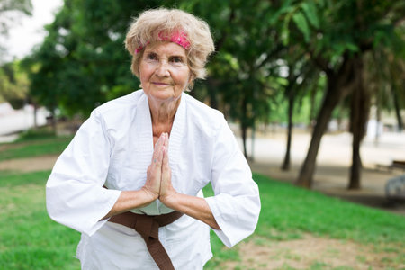 Grandmother training karate in summer parkの写真素材