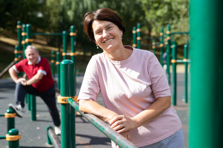 Elderly woman stands in a sports bar on an outdoor sports fieldの写真素材