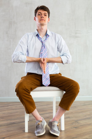 Young guy doing exercises on chairの写真素材