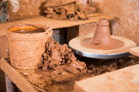Potter wheel, equipment for ceramic workshop. Working process of creating clay dishes closeupの写真素材