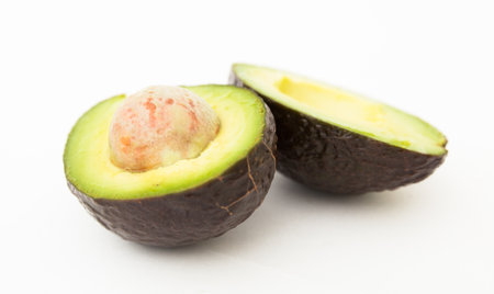 Halved avocado with bone on white backgroundの写真素材