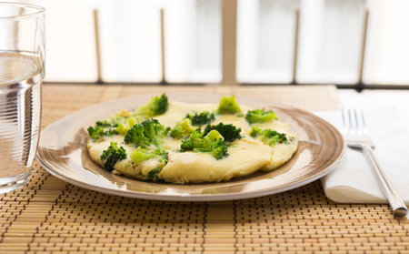 Wholesome breakfast. Omelet with broccoli on brown plateの写真素材