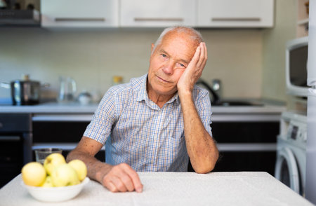 Portrait of old man in kitchenの写真素材