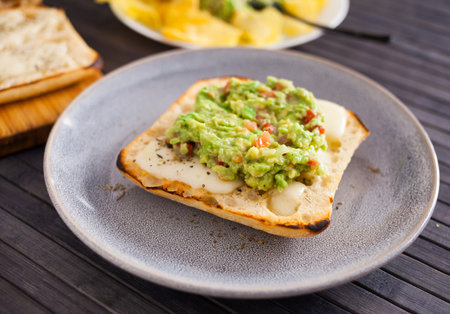 Healthy breakfast. toasted italian ciabatta bread with melted cheese and avocado pureeの写真素材