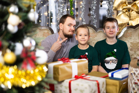 Happy father with children celebrating Christmas and giving each other giftsの写真素材