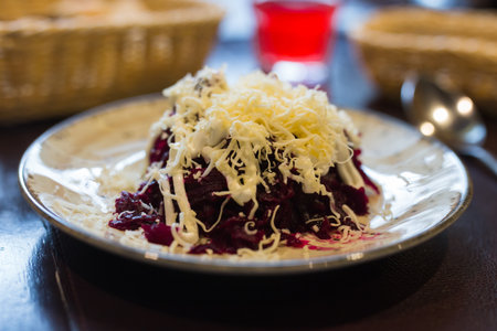 dish of beets, cheese, mayonnaise on a plate in restaurantの写真素材