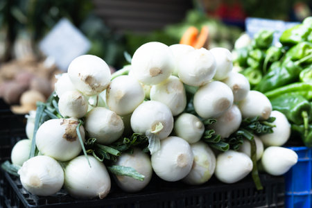 Pile of onions displayed on market counterの写真素材