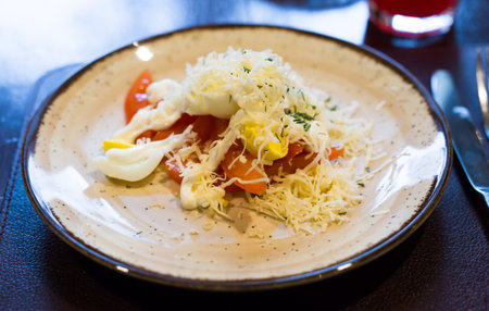mix of tomatoes, cheese, eggs with mayonnaise on a plate in a restaurantの写真素材