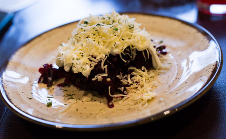 dish of beets, cheese, mayonnaise on a plate in restaurantの写真素材