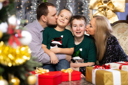 Family with mom and dad celebrates Christmas at homeの写真素材
