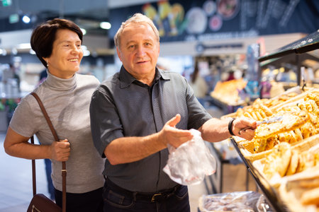 couple chooses sweet puffs in bakeryの写真素材