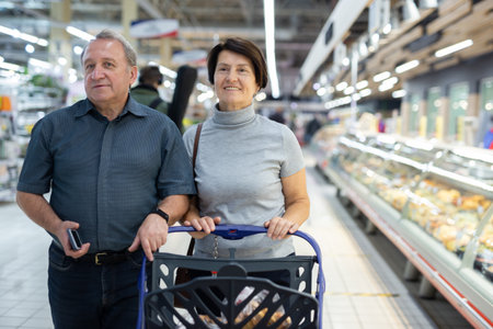 couple walking through supermarket doing shoppingの写真素材