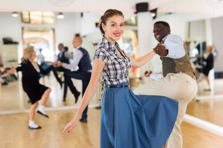 Man and woman performing jazz dance in dancing room