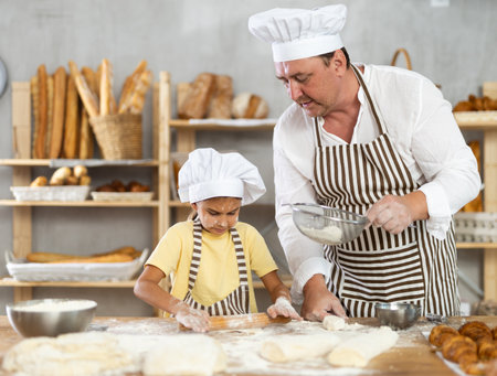 Bakers dad teaches daughter niece to work with dough, using rolling pin