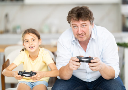 Father and daughter playing video game console