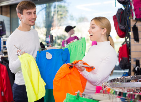 Married couple choosing summer shorts together in clothing storeの写真素材