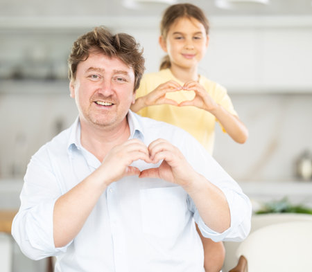 Father and daughter posing in kitchen at homeの写真素材