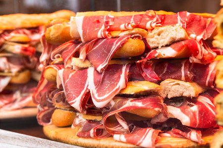 Spanish bocadillos with Iberian ham, laid out in a slide on the display case