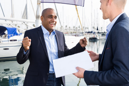 two men in suits buy and sell a yacht in the seaportの写真素材