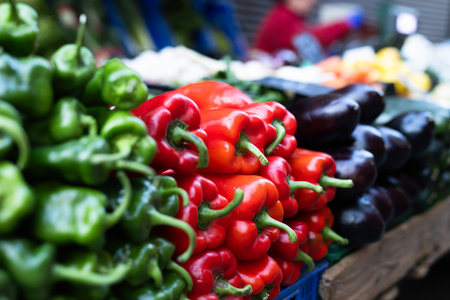 Pile of bell peppers displayed on market counterの写真素材
