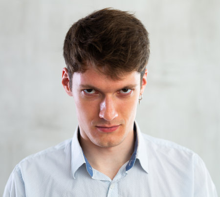 Portrait of young serious guy in studioの写真素材