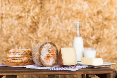 whole head of ripe country cheese and slices and milkの写真素材