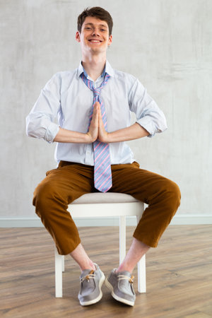 Yoga for office workers - man practicing yoga in officeの写真素材