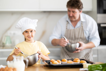 Father and daughter preparing muffins in kitchenの写真素材